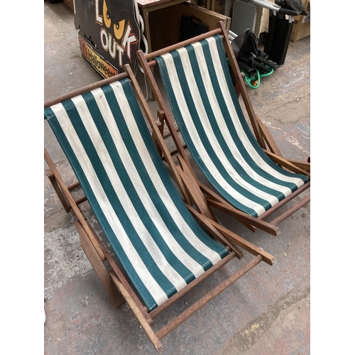 883 - A pair of teak and cloth folding sun loungers