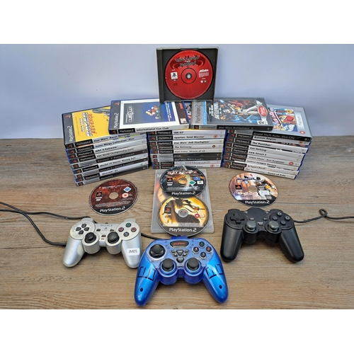 A box containing three PlayStation two controllers and various games