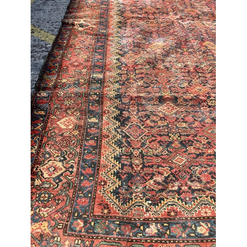 120 - An antique Persian hand knotted rug - approx. 300cm x 156cm