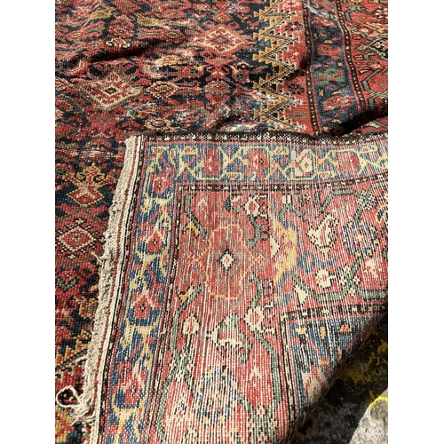 120 - An antique Persian hand knotted rug - approx. 300cm x 156cm