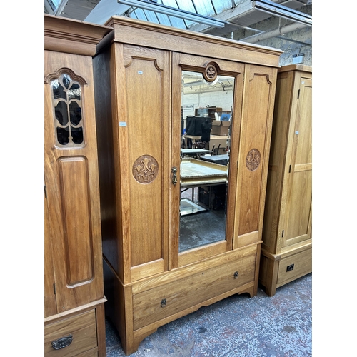 142 - An Edwardian carved oak mirror door wardrobe - approx. 200cm high x 125cm wide x 51cm deep