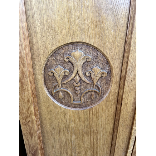 142 - An Edwardian carved oak mirror door wardrobe - approx. 200cm high x 125cm wide x 51cm deep