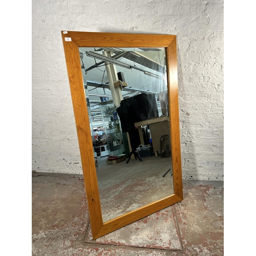 145 - A pine framed bevelled edge wall mirror - approx. 147cm x 90cm