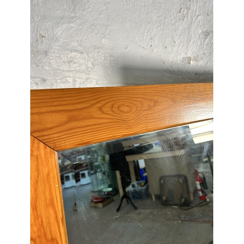 145 - A pine framed bevelled edge wall mirror - approx. 147cm x 90cm