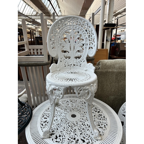 167 - A Victorian style white painted cast metal patio table and two chairs - table approx. 70cm high x 80... 