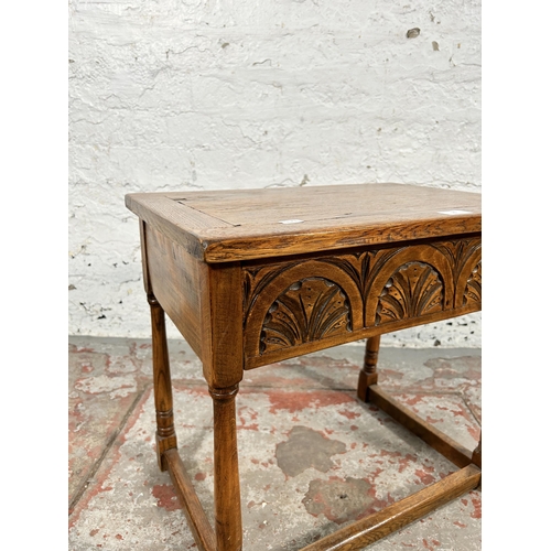 20 - A 17th century style carved oak side table with hinged lid and turned supports