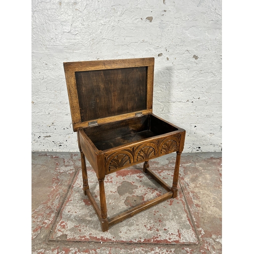 20 - A 17th century style carved oak side table with hinged lid and turned supports