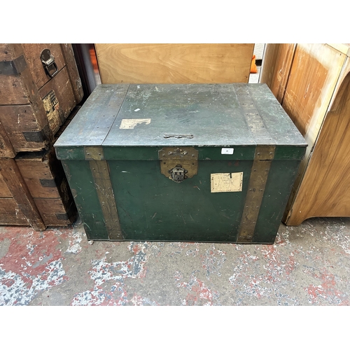 28 - An early 20th century green metal and brass banded travel trunk - approx. 52cm high x 84cm wide x 59... 