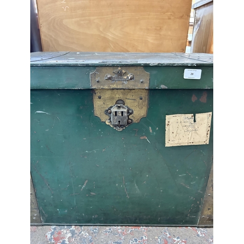 28 - An early 20th century green metal and brass banded travel trunk - approx. 52cm high x 84cm wide x 59... 