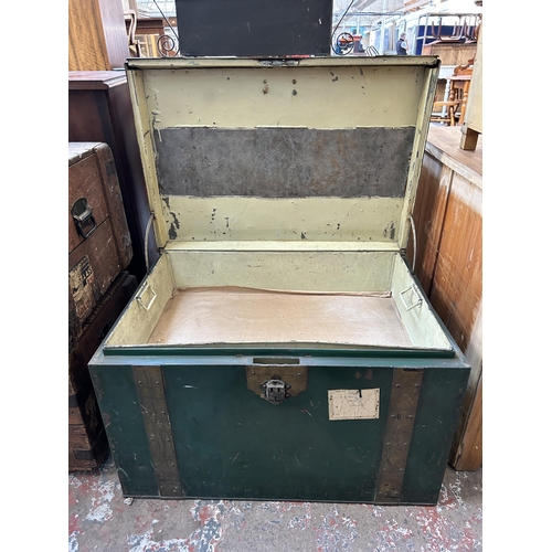 28 - An early 20th century green metal and brass banded travel trunk - approx. 52cm high x 84cm wide x 59... 