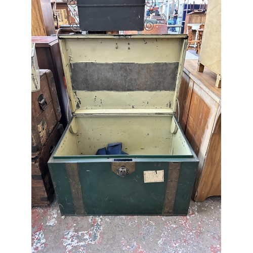 28 - An early 20th century green metal and brass banded travel trunk - approx. 52cm high x 84cm wide x 59... 