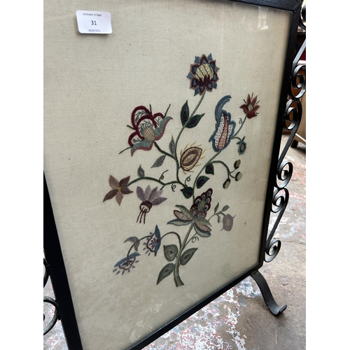 31 - A wrought iron and floral embroidered fire screen