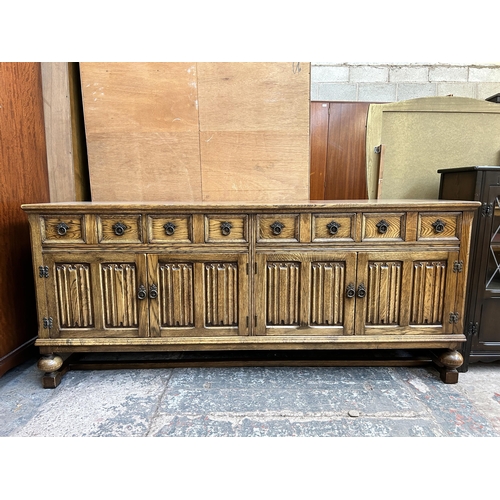 41 - An oak linenfold sideboard on baluster supports - approx. 83cm high x 192cm wide x 49cm deep