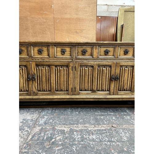 41 - An oak linenfold sideboard on baluster supports - approx. 83cm high x 192cm wide x 49cm deep