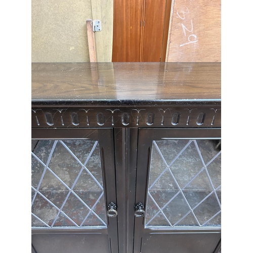 45 - An oak bookcase with two leaded glass doors