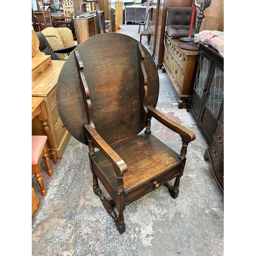 48 - A 17th century style oak monk's seat - approx. 127cm high x 88cm wide x 47cm deep