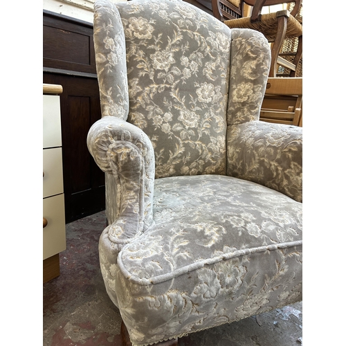 70 - A Georgian style fabric upholstered wing back armchair on ball and claw supports