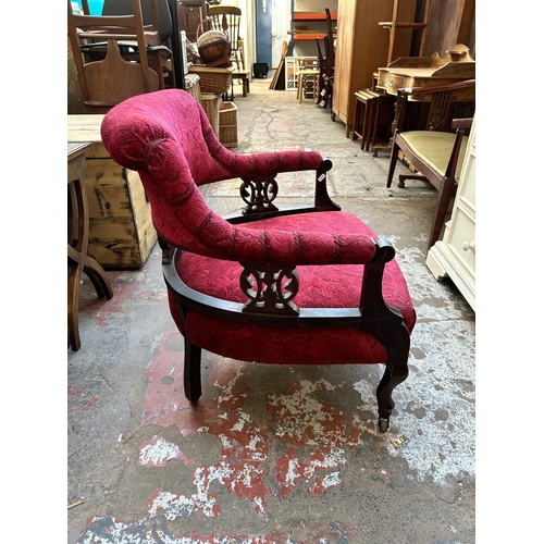 77 - A Victorian carved mahogany and fabric upholstered parlour chair on castors