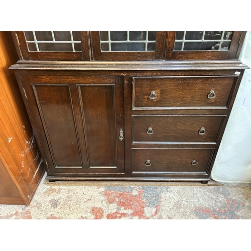 8 - A mid 20th century oak bookcase with three leaded glass doors - approx. 194cm high x 122cm wide x 33... 