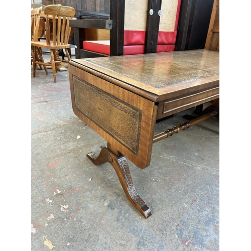 177 - A Regency style mahogany and brown leather drop leaf coffee table with lower stretcher