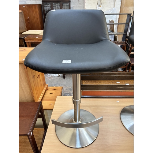 87 - A pair of modern black leatherette and brushed steel kitchen bar stools