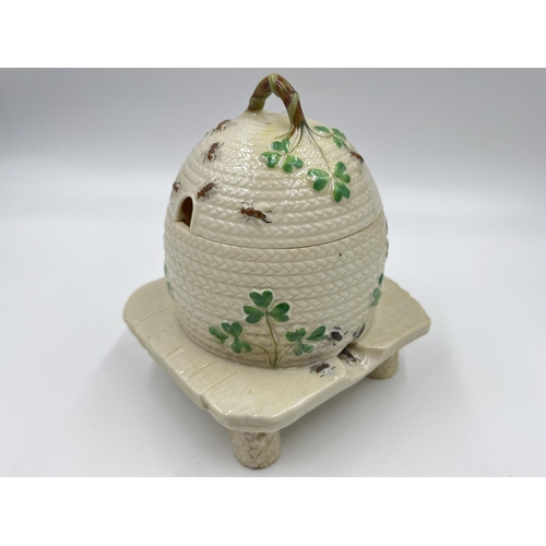 313 - A Belleek Shamrock honey pot on stand - approx. 15cm high