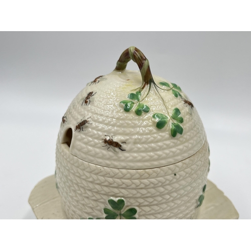 313 - A Belleek Shamrock honey pot on stand - approx. 15cm high