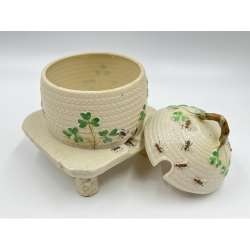 313 - A Belleek Shamrock honey pot on stand - approx. 15cm high