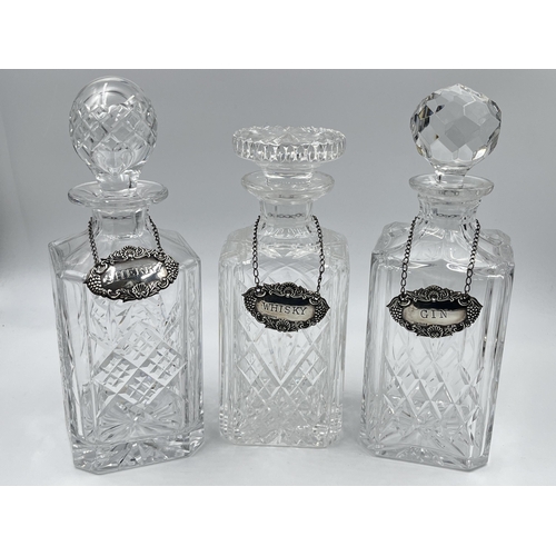 329 - Three crystal glass decanters with three Broadway & Co hallmarked Birmingham silver decanter labels,... 