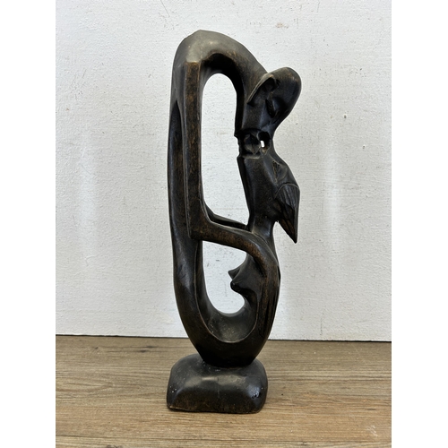 616 - A carved hardwood kissing couple statue - approx. 36cm high