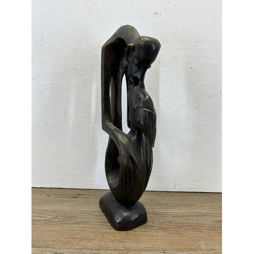 616 - A carved hardwood kissing couple statue - approx. 36cm high