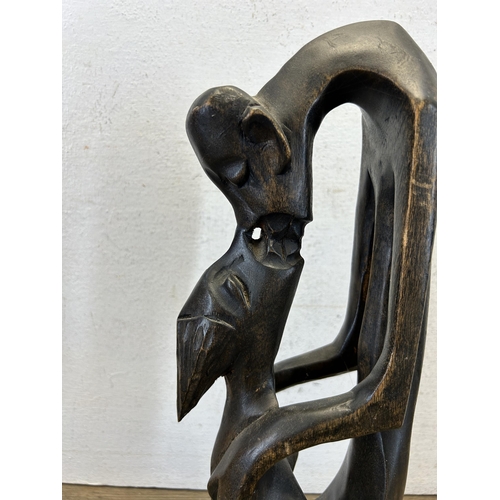 616 - A carved hardwood kissing couple statue - approx. 36cm high