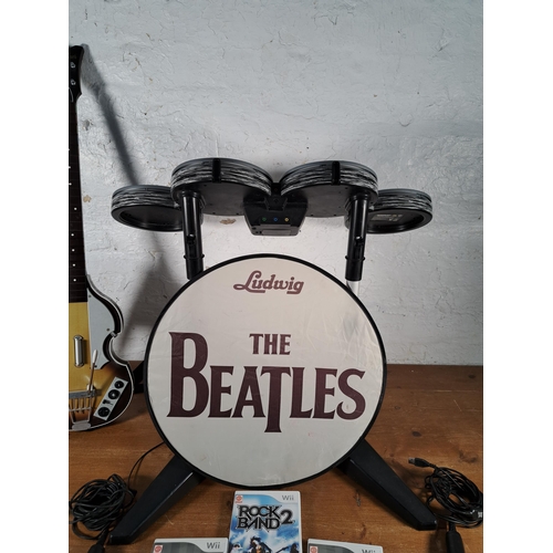 814 - A collection of Rock Band items to include limited edition Beatles Höfner bass and drum Wii controll... 