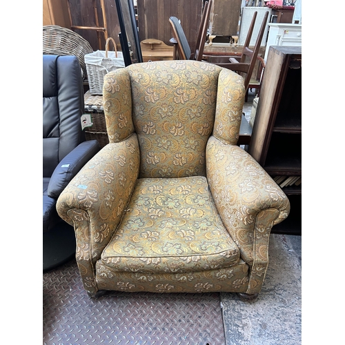 51 - An early 20th century floral upholstered wing back armchair with turned supports and castors