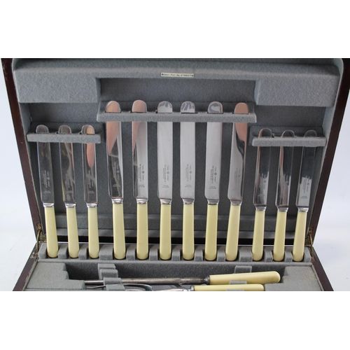 442 - A vintage ivorine fifty three piece carving cutlery set in wooden canteen