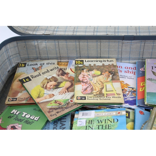 579A - A vintage suitcase containing a collection of Ladybird books