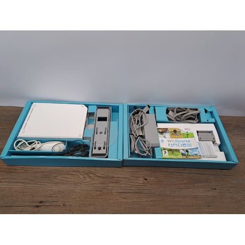 809 - A boxed Nintendo Wii console with controllers, games and third-party fitness board