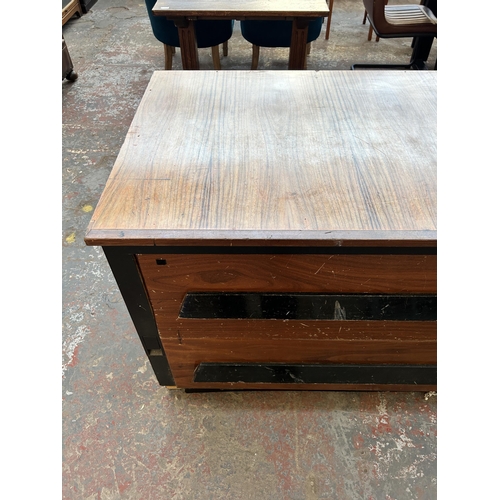 232 - A mid 20th century walnut effect and ebonised four drawer shop counter - approx. 85cm high x 205cm w... 