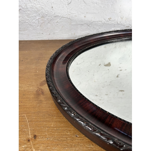 242 - An early 20th century wooden framed oval bevelled edge wall mirror - approx. 89cm x 62cm