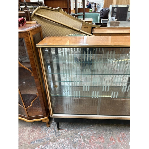 108 - A mid 20th century teak and ebonised mirror back display cabinet with two glazed doors and two inter... 