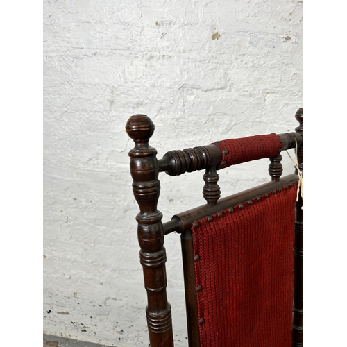 123 - An early 20th century American mahogany and red fabric upholstered rocking chair