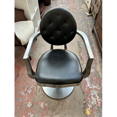 143 - A brushed steel and black vinyl salon chair