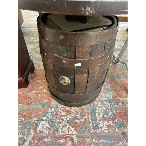 147 - An oak and metal banded barrel side table with circular top - approx. 57cm high x 60cm diameter