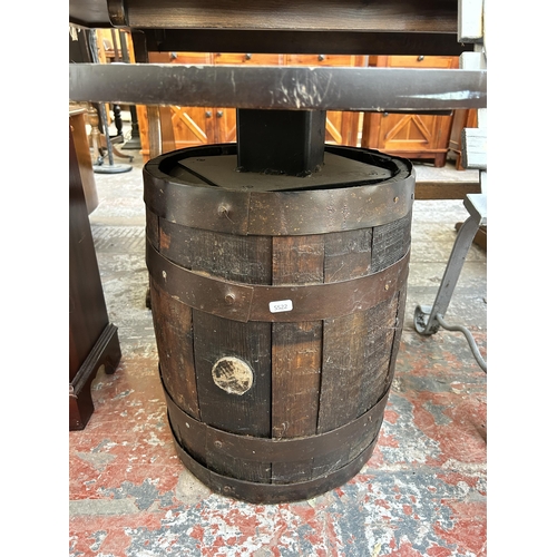 147 - An oak and metal banded barrel side table with circular top - approx. 57cm high x 60cm diameter