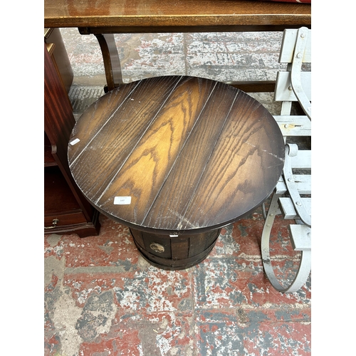 147 - An oak and metal banded barrel side table with circular top - approx. 57cm high x 60cm diameter