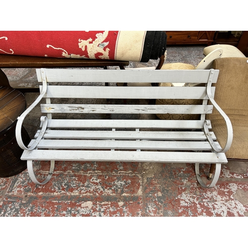 148 - A grey painted wrought iron and wooden slatted garden bench