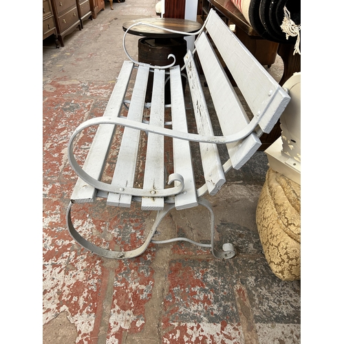 148 - A grey painted wrought iron and wooden slatted garden bench