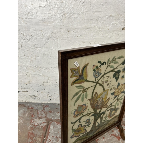 152 - An early 20th century oak framed floral embroidered fire screen - approx. 76cm high x 51cm wide