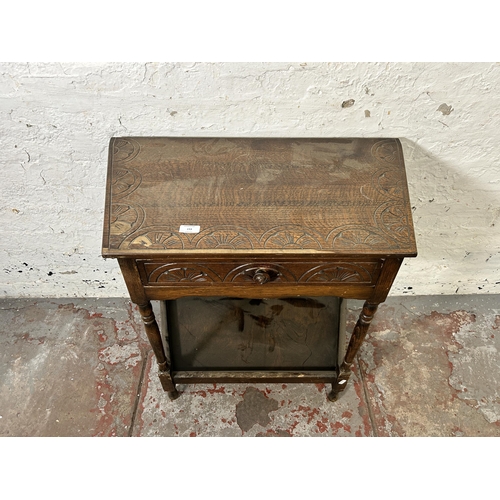 153 - A 17th century style carved oak two tier side table