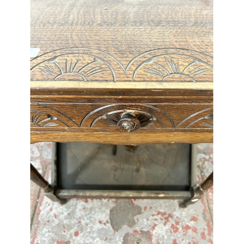 153 - A 17th century style carved oak two tier side table